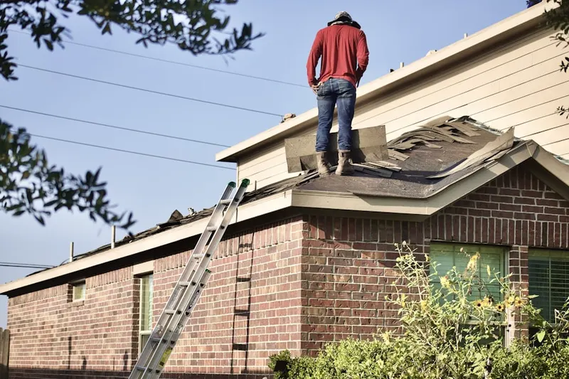 Professional roofer working on a residential roof in Broadmoor Oaks